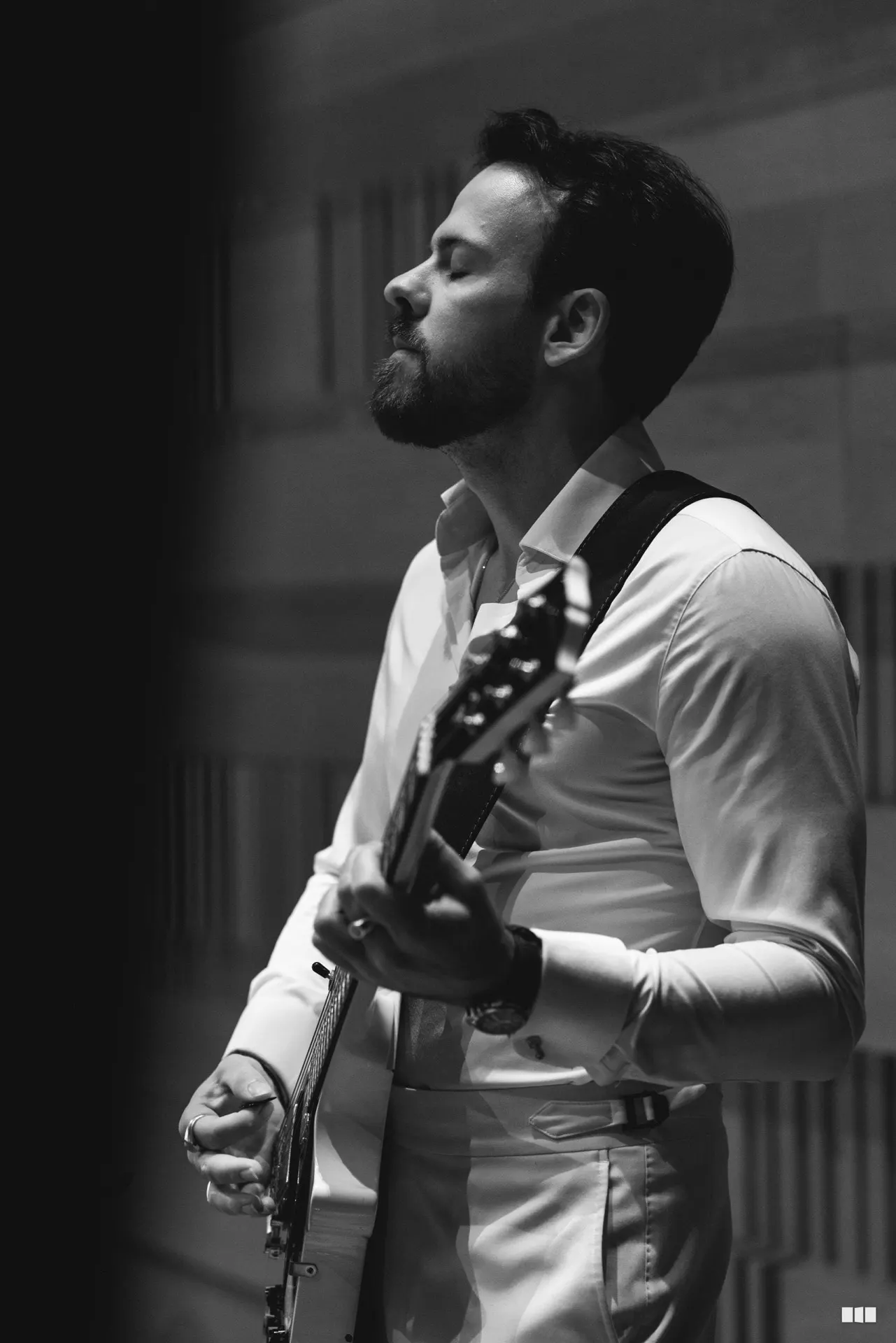 Guitarist playing eyes-closed in worship during an orchestral concert