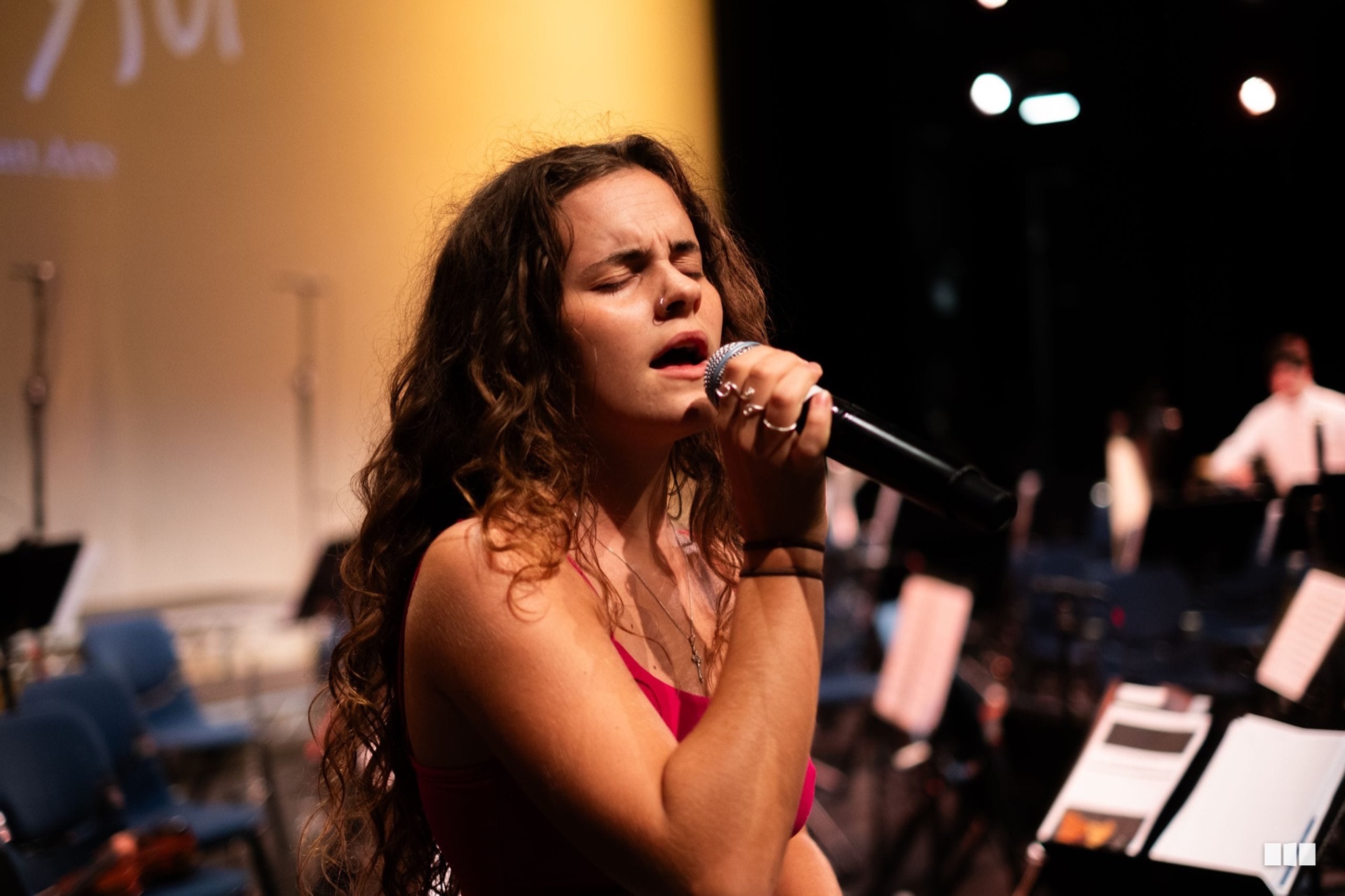 Soloist singing in worship with the Australian Christian Orchestra behind her