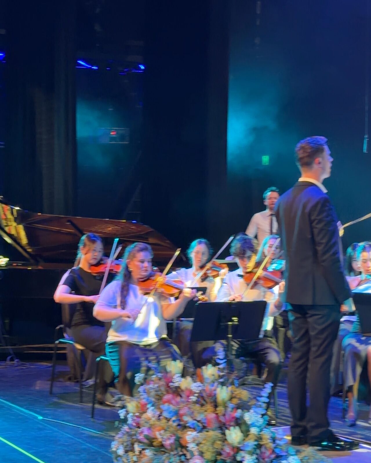 Young violinists of the Australian Christian Youth Orchestra following the conductor at the Proms, 2026