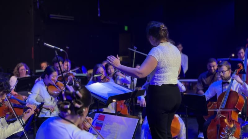 A conductor leading an orchestra during a performance.